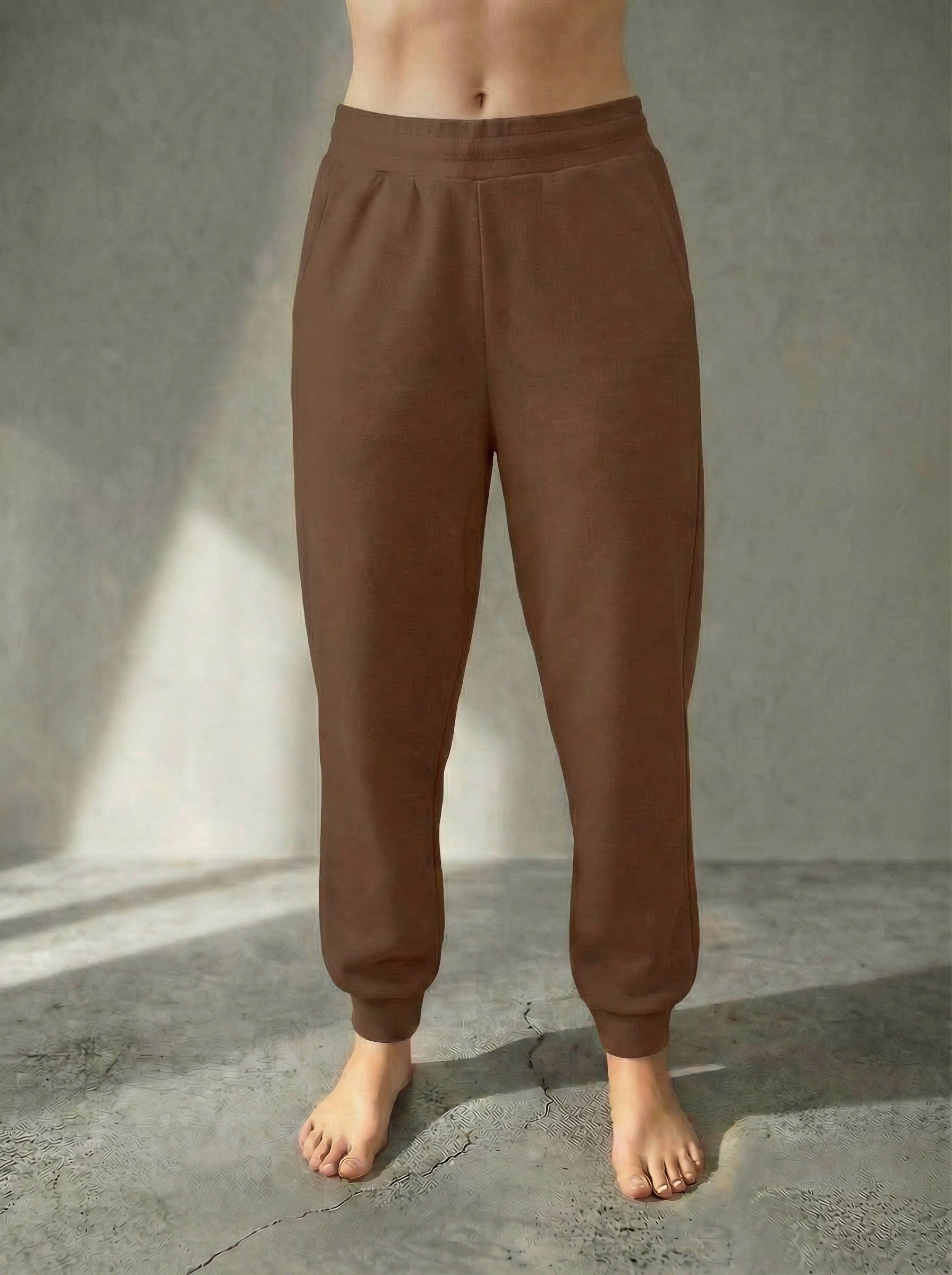 Front view of the Deryn Jogger women’s luxury jogger pants by BOU Clothing in Tan, shown on a model standing barefoot against a beige backdrop.