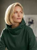 Model wearing Bou Clothing’s Forest luxury Deryn hoodie in a softly lit modern interior, showcasing a relaxed fit, premium fabric, and minimalist neutral style.