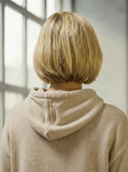 Model wearing Bou Clothing’s cream luxury hoodie in a softly lit modern interior, showcasing a relaxed fit, premium fabric, and minimalist neutral style.