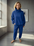 Model wearing Bou Clothing’s Cornflower luxury hoodie and matching joggers, in a softly lit modern interior, showcasing a relaxed fit, premium fabric, and minimalist neutral style.