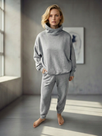 Model wearing Bou Clothing’s Gret Deryn luxury hoodie and matching joggers, in a softly lit modern interior, showcasing a relaxed fit, premium fabric, and minimalist neutral style.