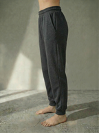 Side view of Deryn Jogger from Bou Clothing in Balck Marl colour against a stone grey background.